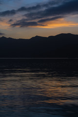 Minimalist seaside panorama with hills and reflections on the water