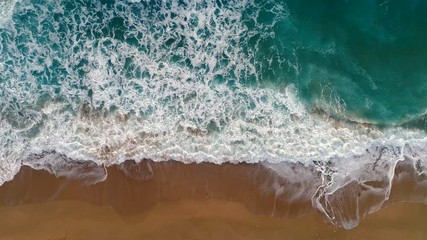 Sea or ocean surf wave. Foamy ocean waves rolling and coming on a sand beach. Aerial top down shot, 4K - Powered by Adobe