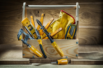 big set of working tools in vintage wooden toolbox on wood background