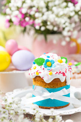 Traditional Easter cake with white icing decorated  sugar flowers and colorful eggs