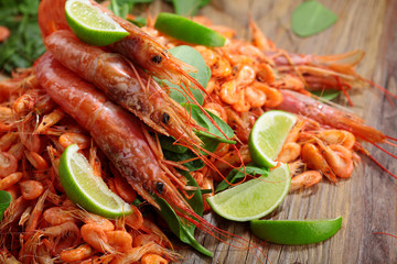Pile of shrimp on wooden table.Shrimps.Raw fresh big shrimps with lime