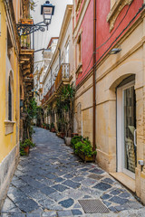 Narrow italian street in the ancient Ortygia island, Syracuse, Sicily, Italy