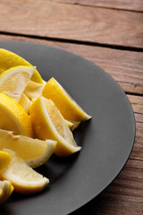 Fresh lemon.Slice of lemon on black plate.Top view.Copy space.