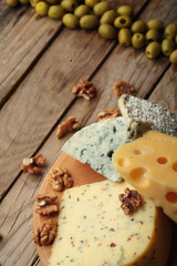Various types of cheese on wooden board.Copy space.Chessnut.Olives