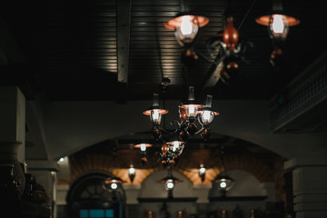 The old black chandelier lights up in a restaurant.