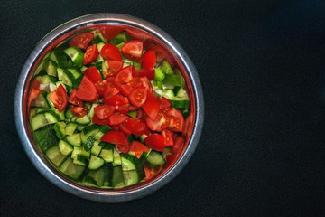 Bowl of salad on black.