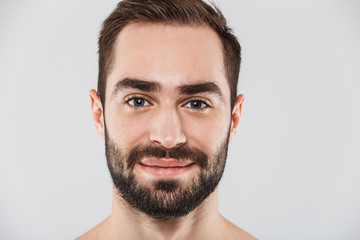 Close up of a young handsome bearded shirtless man
