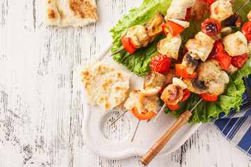 Chicken skewers with mushrooms, vegetables and fresh lettuce.