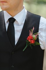 Young man in costume with a bouquet in his chest.