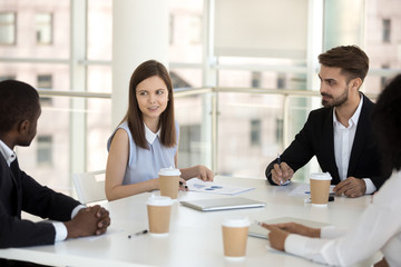 Diverse business team discussing sitting together at meeting
