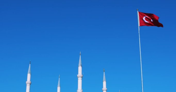 Sabanci Central Mosque and Turkish flag in Adana, Seyhan city of Turkey. Turkish flag waving at blue sky with mosque minarets. Turkish islamic republic country. Travel to Turkey. 