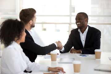 Diverse workers greeting each other in briefing shaking hands