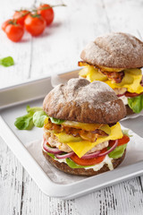 Chicken cheeseburger with bacon, lettuce, tomato and mayonnaise