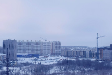Under construction neighborhood with high-rise buildings in the city in the winter.