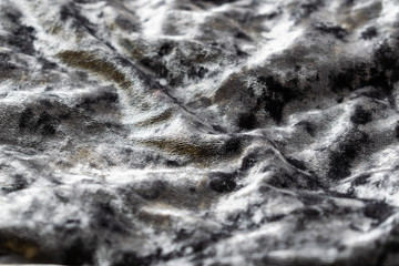 Grey, pinkish, purple velvet background. Soft textile fabric, pleasant to the touch. Delicate material, crumpled and collected in different directions. In the light with shadows.  Pronounced texture.