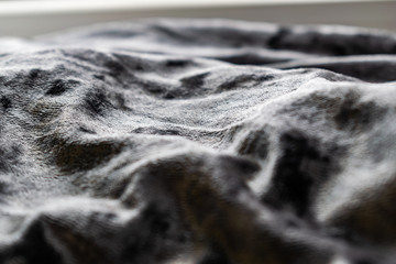 Grey, pinkish, purple velvet background. Soft textile fabric, pleasant to the touch. Delicate material, crumpled and collected in different directions. In the light with shadows.  Pronounced texture.