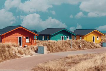 colorful wooden tiny houses on the island Dune near island Helgoland against blue sky.