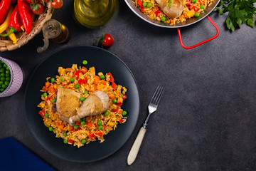 Arroz con pollo. Baked pieces of chicken with bone, rice with paprika and peas.