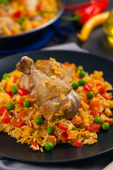 Arroz con pollo. Baked pieces of chicken with bone, rice with paprika and peas.