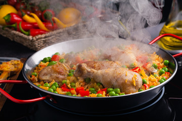 Arroz con pollo. Baked pieces of chicken with bone, rice with paprika and peas.