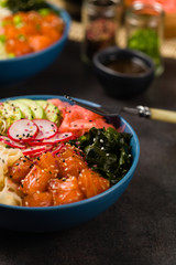 Hawaiian salmon poke bowl with seaweed, avocado, sesame seeds.