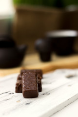chocolate candies on clay teapot background