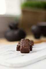 chocolate candies on clay teapot background