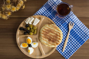breakfast concept with wooden service plate ,a cup of tea and blue cover for cafe concept.