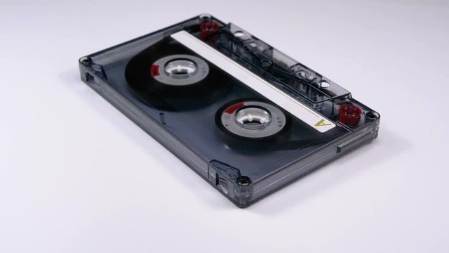 Vintage Transparent Audio Cassette Rotates on White Background