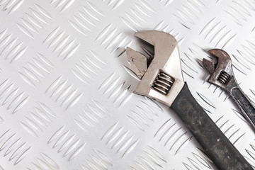 Big and small wrench on metal background