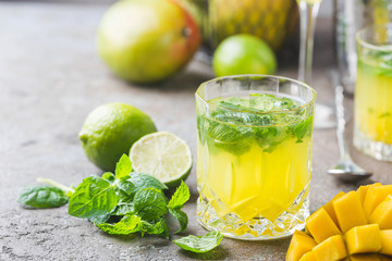 Fresh mango mojito cocktail with lime and mint in a glass