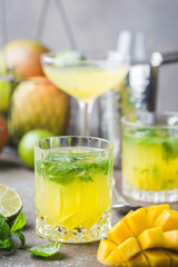 Fresh mango mojito cocktail with lime and mint in a glass