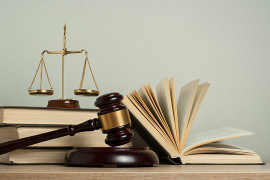 Law concept. Wooden judge gavel with law books ,scales of justice on table in a courtroom or enforcement office.