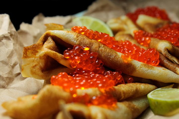 Red salmon caviar on pancakes