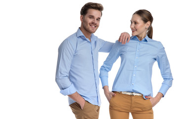 smiling casual man leans elbow on woman's shoulder