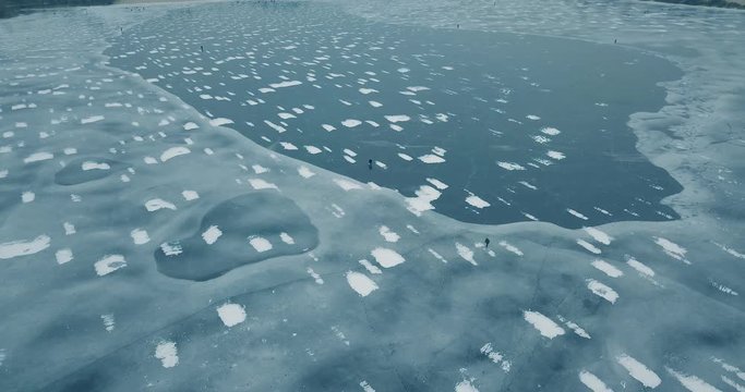 Aerial drone footage of frozen river in winter day.Flying quadro copter camera shoot video of ice on sea water surface in cold season.Beautiful landscape from above.Travel destination for tourism