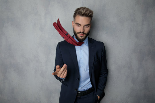 cool businessman pointing finger while his tie is flying