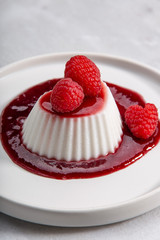 Vegan coconut Raspberry panna cotta decorated with ripe berry