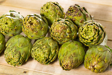 Obraz premium Artichokes on wooden table