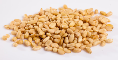 Fototapeta premium Pile of delicious pine nuts on a white surface