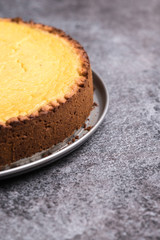 Tasty homemade vegan lemon cheesecake on dark gray stone plate