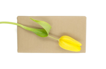 Kraft gift box with yellow tulip is on a white background