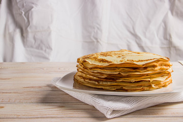 A big pack of delicious pancakes on a white plate with milk
