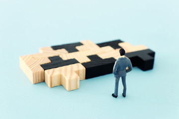 puzzle blocks with miniature people over wooden table ,human resources, problem solving and management concept