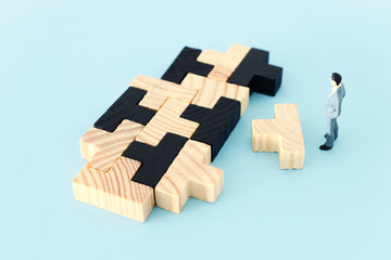 puzzle blocks with miniature people over wooden table ,human resources, problem solving and management concept