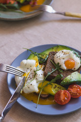 sandwich with avocado, poached egg, arugula and cherry tomatoes
