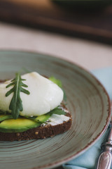 sandwich with avocado, poached egg, arugula and cherry tomatoes