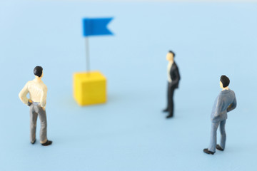 miniature people looking at destination pin sign