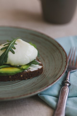 sandwich with avocado, poached egg, arugula and cherry tomatoes