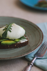 sandwich with avocado, poached egg, arugula and cherry tomatoes